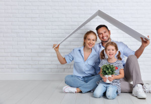 concept housing   young family. Mother father and child in new house with  roof at empty brick wall